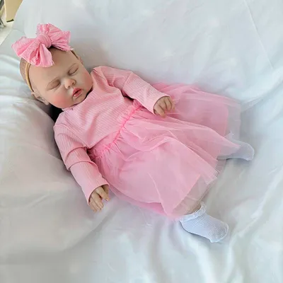 Zdjęcie produktu dla 60 cm, duże ciało z bawełny, zamknięte oczy, rysowane włosy, wszyte rzęsy, różowa sukienka w paski z tiulu z długimi rękawami + białe skarpetki + różowa opaska do włosów z dużą kokardą, realistyczna lalka.