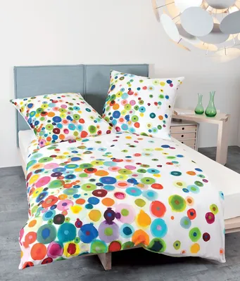 A bed with colorful bedding and pillows.