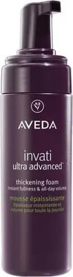 A close-up studio shot of a purple bottle of Aveda Invati Ultra Advanced Thickening Styling Foam.