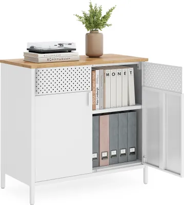 A white metal storage cabinet with a wood-effect top, open doors revealing shelves with binders and books, and decorative polka dots on the drawer front and inside of the doors. A small plant and a record player are on top.