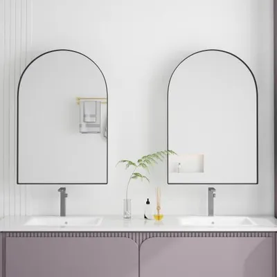 A modern bathroom vanity with two arched mirrors and sinks.