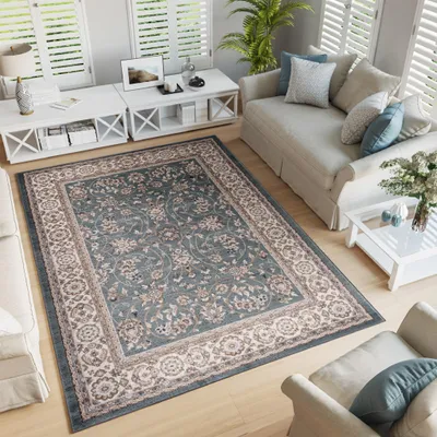 A living room scene with a rug, sofa, and coffee tables.