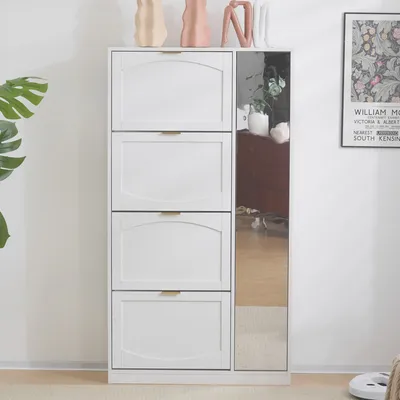 A white shoe cabinet with four flip-down doors and a full-length mirror on the side. Decorative vases and a framed poster are visible on top of and next to the cabinet.
