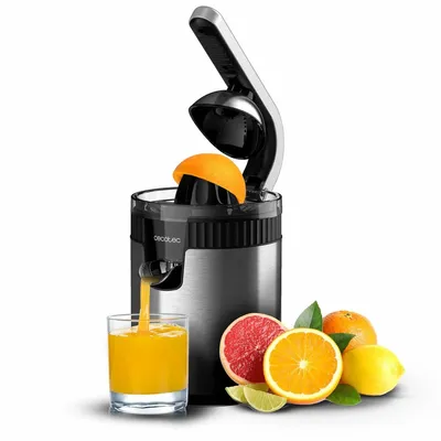 A citrus juicer is shown in operation, with juice flowing into a glass. Several citrus fruits are arranged around the base of the juicer.