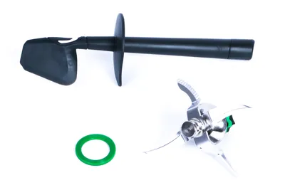 A set of kitchen appliance parts, including a spatula, a blade assembly, and a green gasket, laid out on a white background.