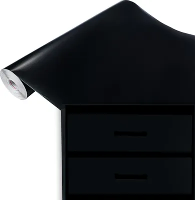 A roll of black contact paper is shown diagonally, partially covering a black drawer unit with two drawers.