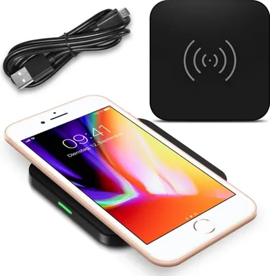 A wireless charger with a phone on it, and a charging cable.