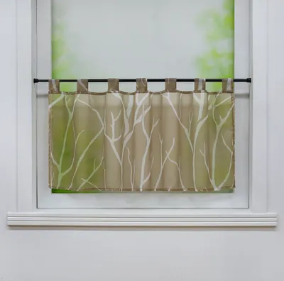 A short, patterned curtain hangs on a rod in a window.