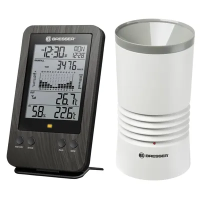 A digital weather station display and a rain gauge are shown against a white background.