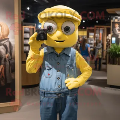 Immagine prodotto di Personaggio del costume della mascotte REDBROKOLY della macchina fotografica gialla vestito con una camicia e orecchini di chambray