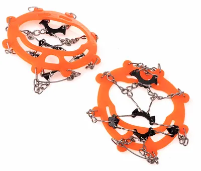 Two orange shoe crampons with metal chains and spikes are shown against a white background.