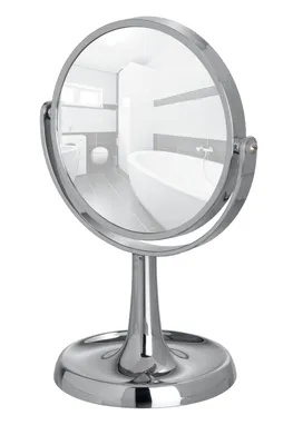 A chrome makeup mirror on a stand, reflecting a bathroom.