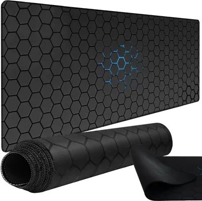 A large black gaming mousepad with a hexagonal pattern and a blue glowing hexagonal design in the center. A portion of the mousepad is rolled up in the foreground.
