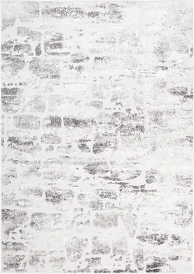 A close-up view of a rug with a distressed brick pattern.