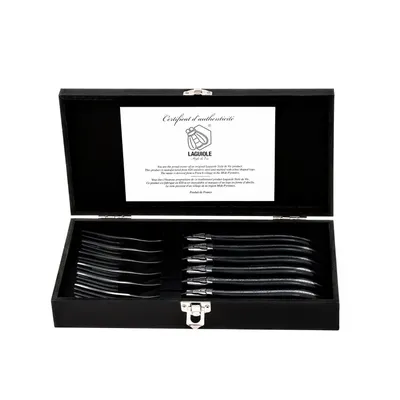 A black wooden box containing a set of six steak forks, with a certificate of authenticity inside the lid.