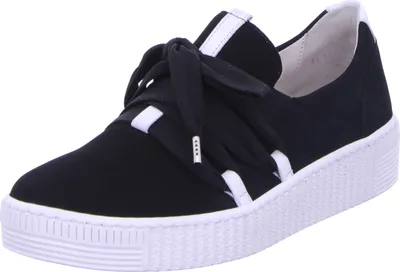 A black sneaker with white accents and a white platform sole is shown against a white background.