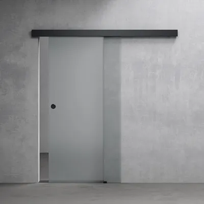 A frosted glass sliding door with a black handle mounted on a concrete wall.