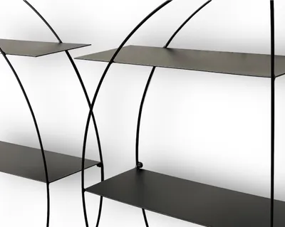 A close-up view of a black metal wall shelf unit against a white background.