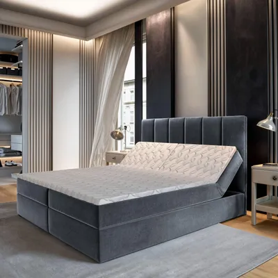A modern bedroom with a boxspring bed, closet, and window.
