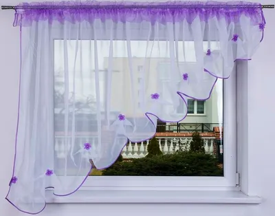 A sheer white curtain with purple trim and floral accents hangs in a window.