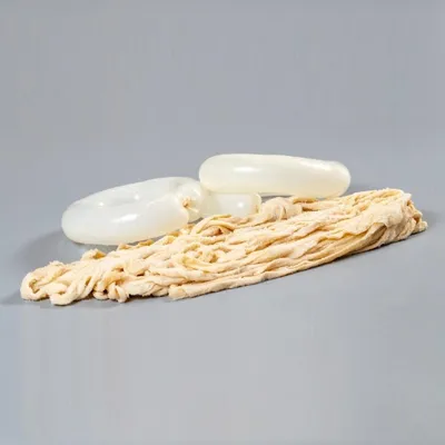 Several lengths of sausage casings are arranged on a plain gray background.
