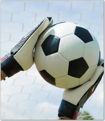 Produktbild von Wallario Herdabdeckplatte aus Glas, Größe 52 x 60 cm 1-teilig, Motiv Fußball - Torwart im Tor vor blauem Himmel