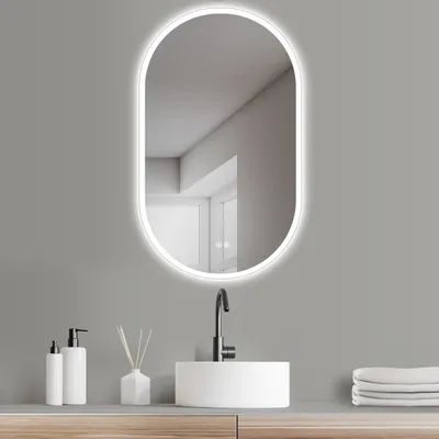 A modern bathroom vanity with a sink, faucet, and an illuminated oval mirror.