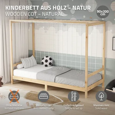 A natural wood children's bed with a canopy frame, set up in a room with decorative wallpaper and bedding.