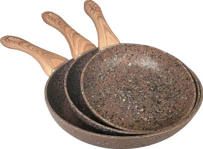 Three frying pans of varying sizes are stacked and angled against a white background.