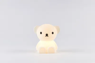 A small, white, bear-shaped night light is centered on a plain white background.