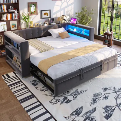 A multi-functional sofa bed with LED lighting is set up in a room with bookshelves and a large window.