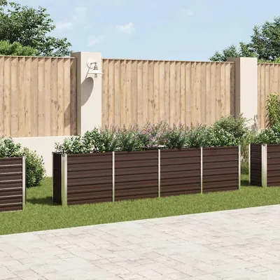 A garden scene with planters and a wooden fence.