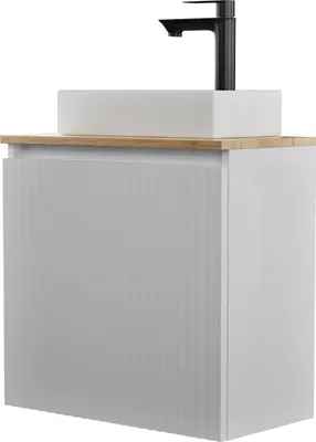 A white bathroom vanity with a rectangular sink and a black faucet on a wooden countertop.