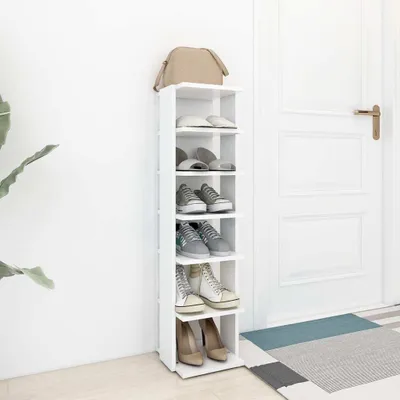 A white shoe rack with various shoes and a bag on it, placed next to a white door.