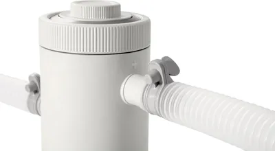 A close-up shot of a white pool filter pump with a white hose attached.