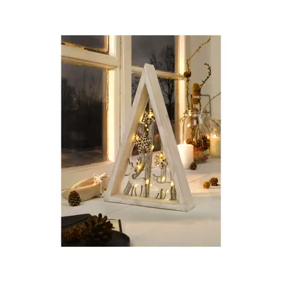 A wooden triangular decoration with LED lights, featuring reindeer and snowflake cutouts, placed on a windowsill with a winter scene outside.