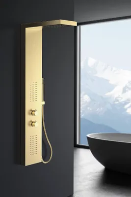 A modern bathroom with a large window overlooking snowy mountains, featuring a gold shower panel and a black bathtub.