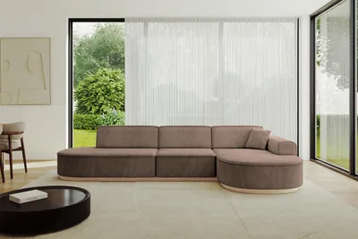 A modern living room with a large sectional sofa, a coffee table, and a large window overlooking a garden.