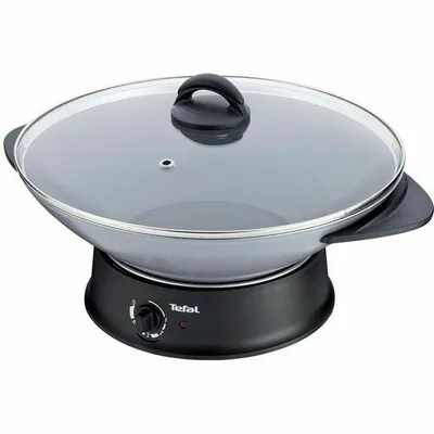 A black electric wok with a glass lid sits on a white background.