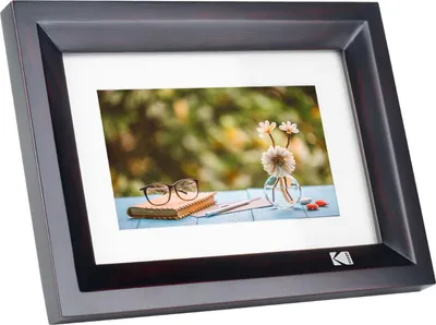 A digital photo frame displaying a still life image of flowers and a book.