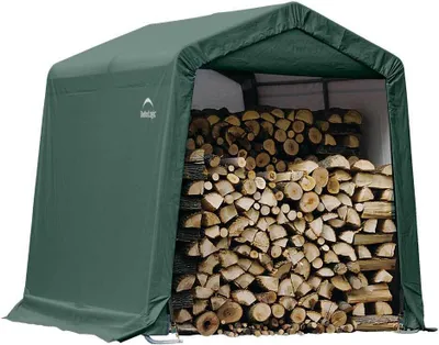 A green storage tent filled with firewood.