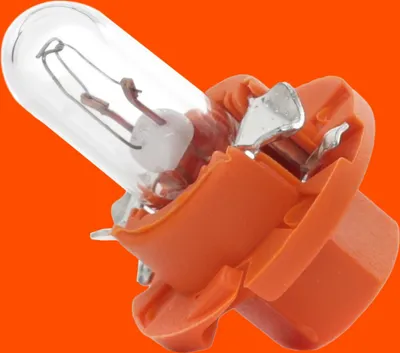 A close-up of a small light bulb with an orange plastic base against an orange background.
