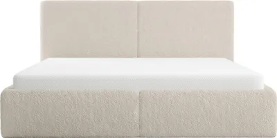 A beige upholstered bed frame with a mattress.