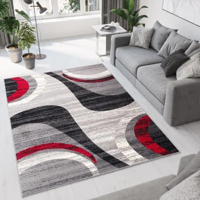 A modern living room with a grey sofa and a rug with a geometric pattern.