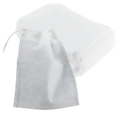 A stack of white tea filter bags with one bag in the foreground.