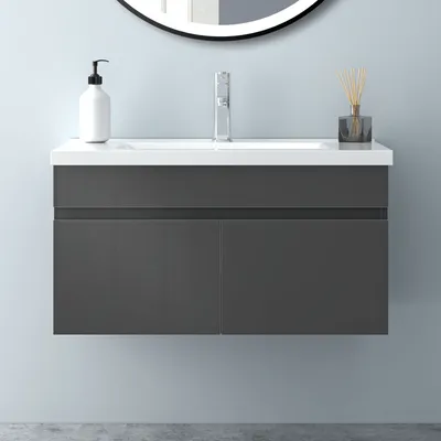 A modern wall-mounted bathroom vanity with a white ceramic sink and a dark gray cabinet, set against a light blue wall.