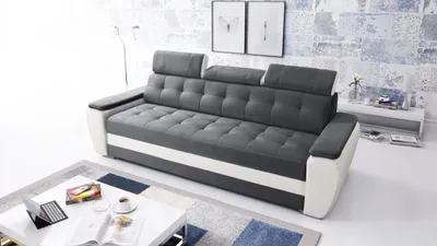 A modern living room with a sofa, coffee table, and artwork on the wall.