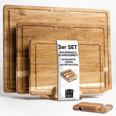 A set of three wooden cutting boards of different sizes, stacked and displayed with a product information card and a small wooden holder.