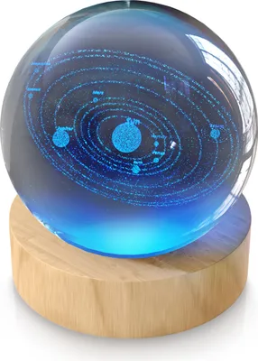 A 3D crystal ball depicting the solar system, illuminated from below by a blue LED light, resting on a wooden base.
