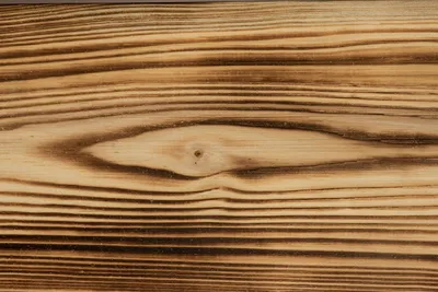 A close-up view of the wood grain and texture of a piece of wood, likely a bed frame.